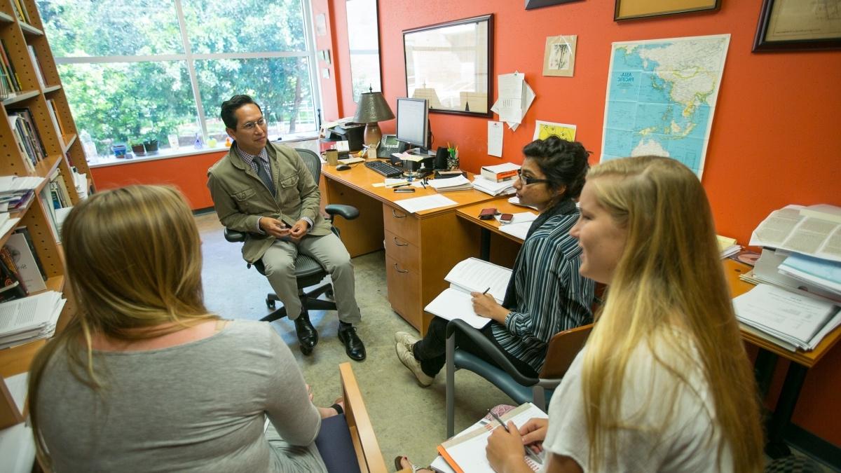 Students gathered around 教授 p艺术icipating in a groupdiscussion